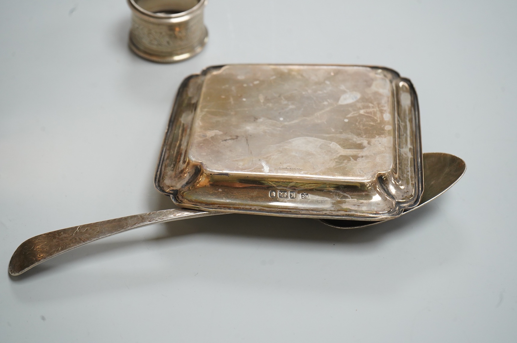 A George VI silver mounted rectangular cigarette box, Atkin Brothers, London, 1944, 17.3cm, together with a small silver dish, William Comyns & Sons Ltd, London, 1945, an Edwardian silver napkin ring and a George III sil